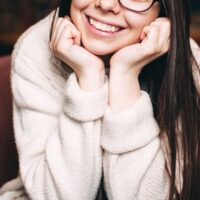 smiling-student-sitting-against-bookshelves-2022-11-03-04-25-20-utc (1)