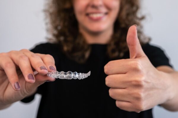 woman-holds-transparent-braces-for-dental-correcti-2022-10-05-17-35-49-utc (1)